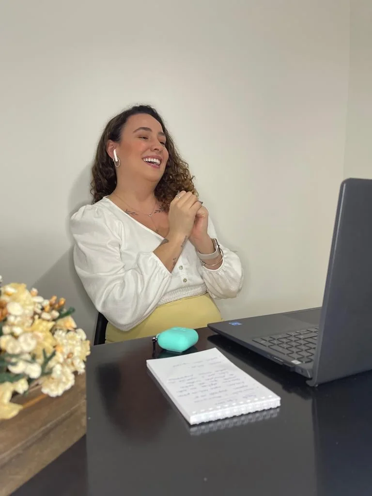Fernanda em atendimento online diante de um notebook